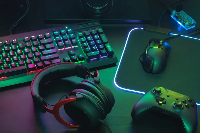 A gaming keyboard, mouse, and headset neatly arranged on a desk representing gaming channel names