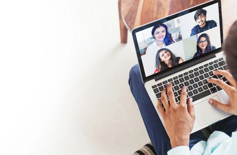  A person using a laptop with a group of people on the screen working to earn money online from home