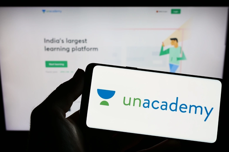 A phone and Lap together its displays unacademy logo and website 