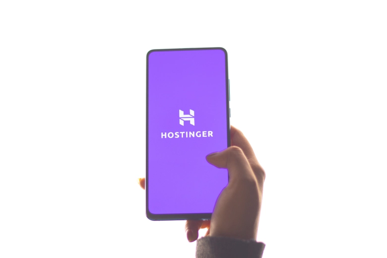 a mobile phone shows of hostinger logo on it 