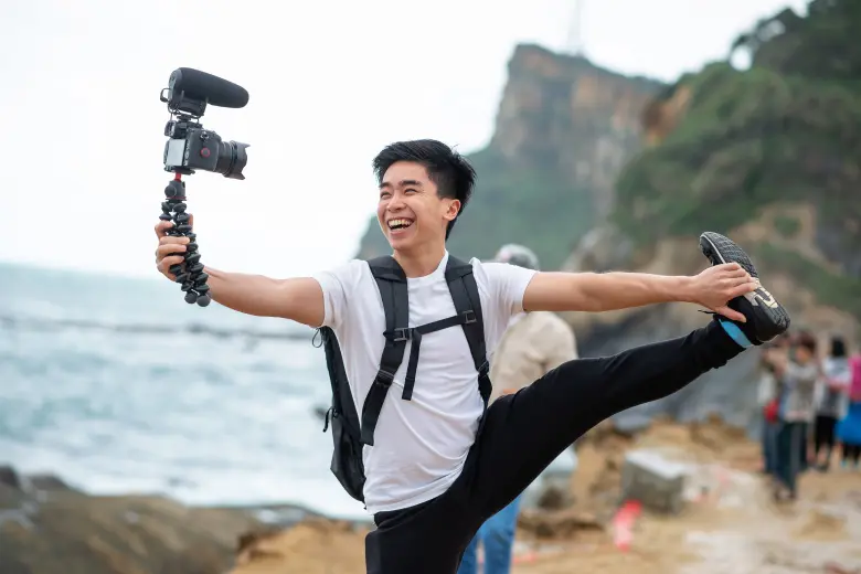 a man holding a camera and earning money by doing by travel vlog
