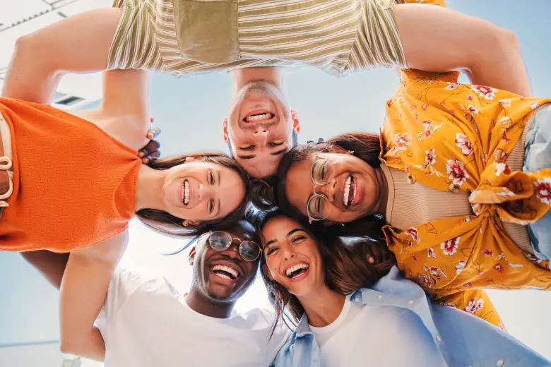 Group of friends standing in a circle and smiling and for good group channel name ideas